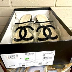 Chanel transparent/black sandals with the large Chanel logo.